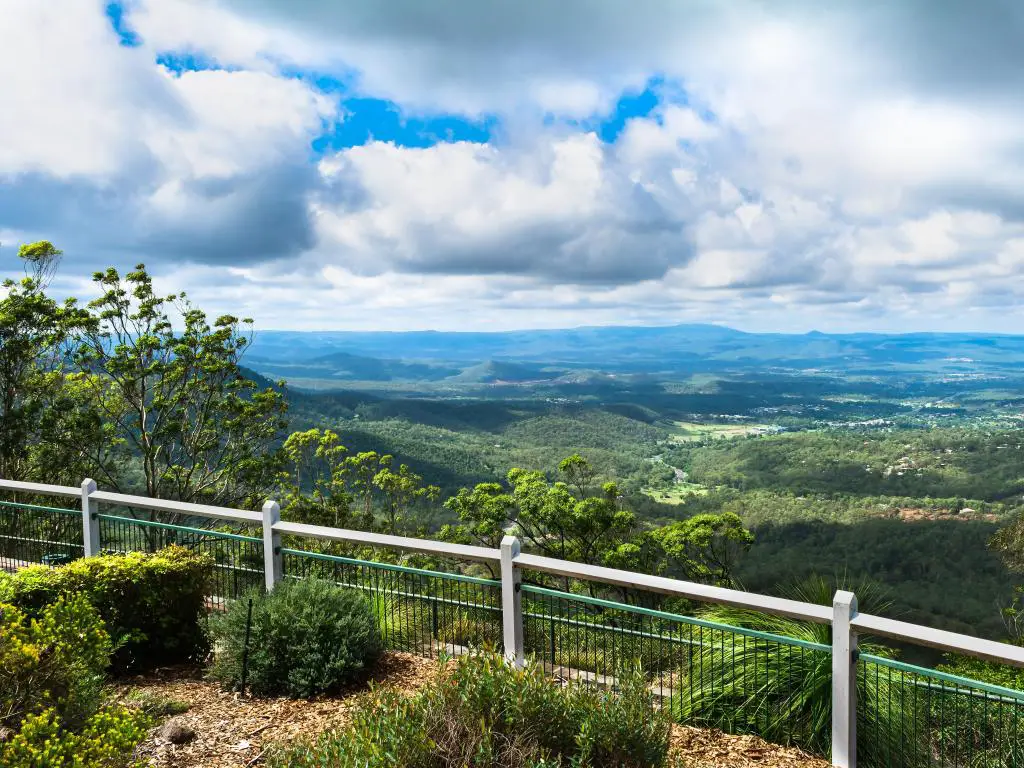 Toowoomba, Australia con una valla en primer plano con vistas panorámicas de tierras planas y montañas debajo en un día soleado.