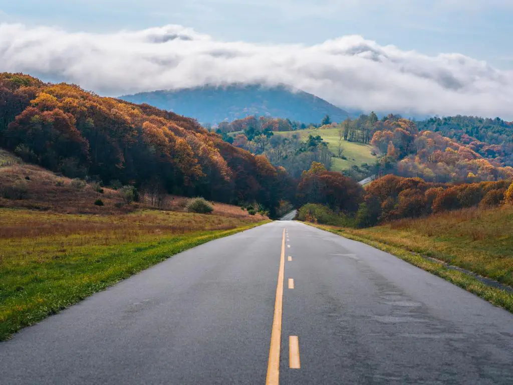 El Blue Ridge Parkway, Virginia, EE.UU. con niebla sobre las montañas de Virginia y la carretera que conduce a la distancia tomada durante el otoño.