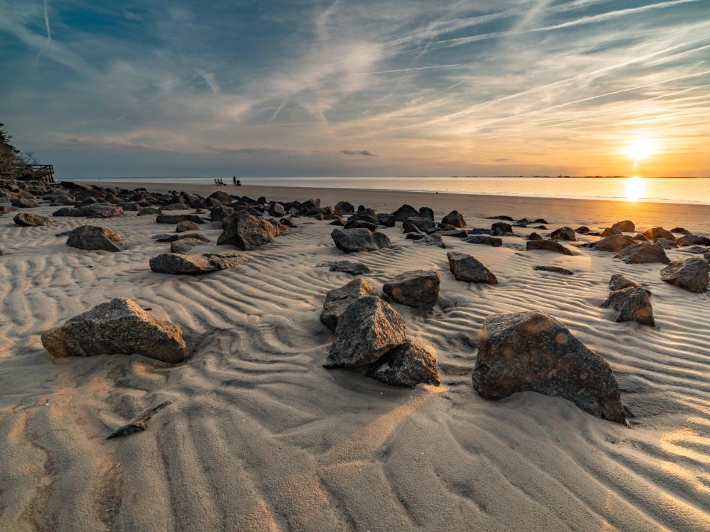 Jekyll Island, GA, EE. UU. Con impresionantes nubes cubren el cielo durante la puesta de sol en Jekyll Island, GA, mostrando las hermosas piedras de la playa.