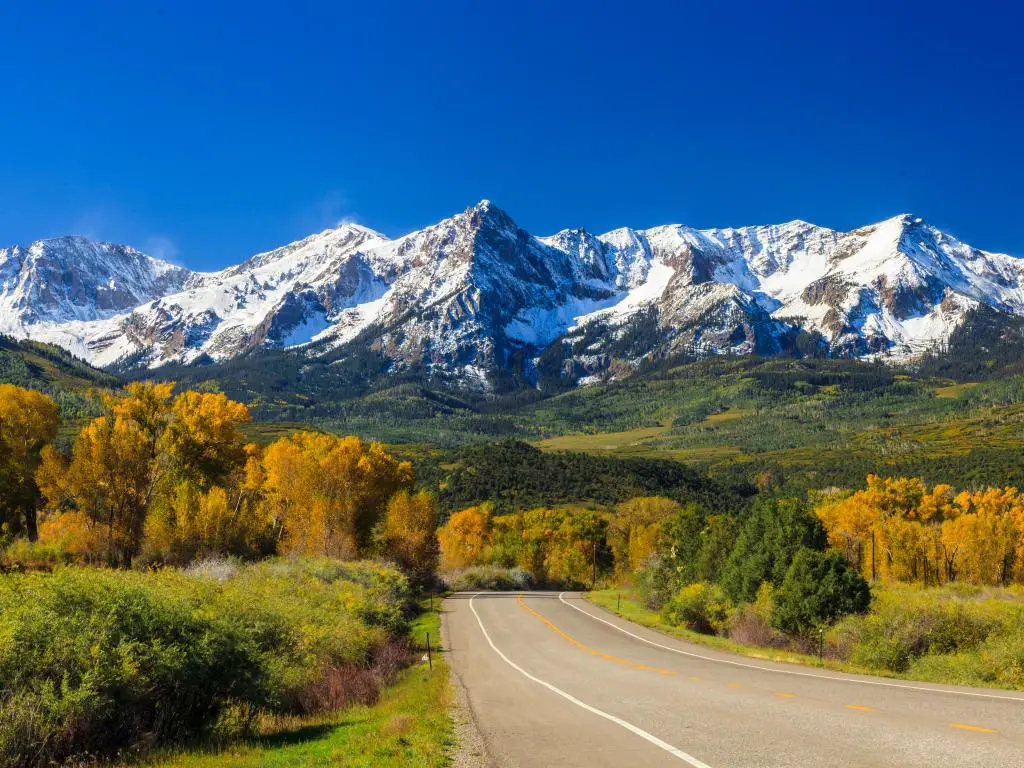 Un camino rural que atraviesa las Montañas Rocosas en Colorado durante el otoño.