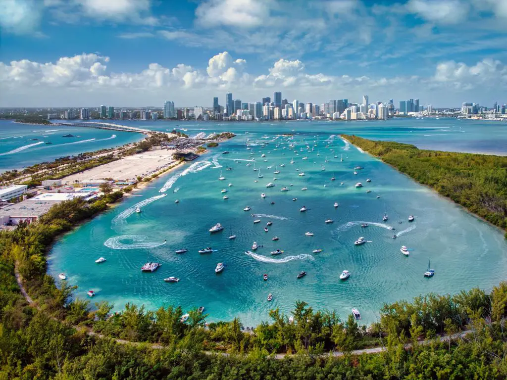 Biscayne Bay, Miami con una vista aérea de los barcos en la bahía en primer plano y el horizonte de Miami en la distancia. 