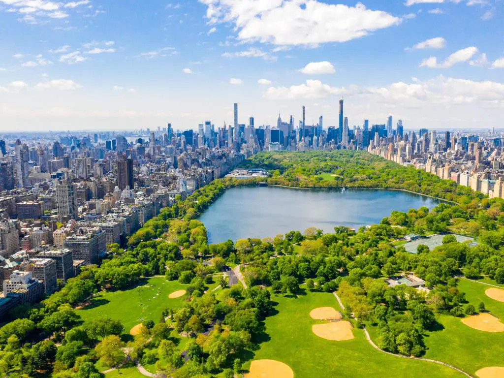 Nueva York, EE. UU. con Central Park tomada como una vista aérea, rodeada de rascacielos al fondo y tomada en un día soleado.