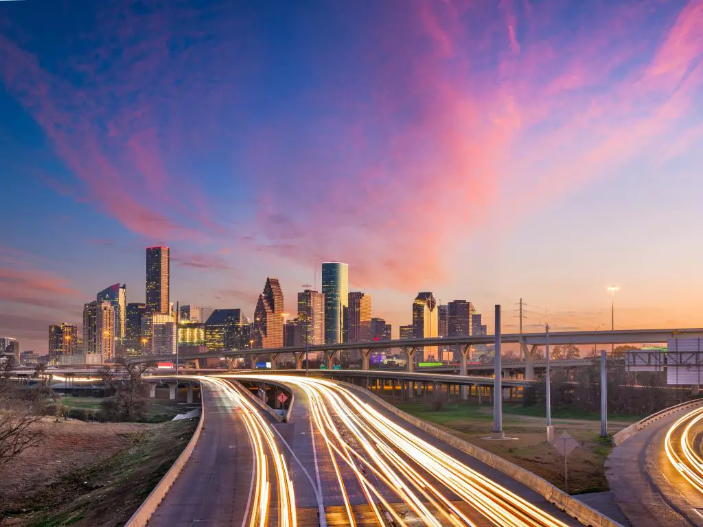 Houston, Texas, EE.UU. con el horizonte del centro de la ciudad sobre las carreteras al atardecer.