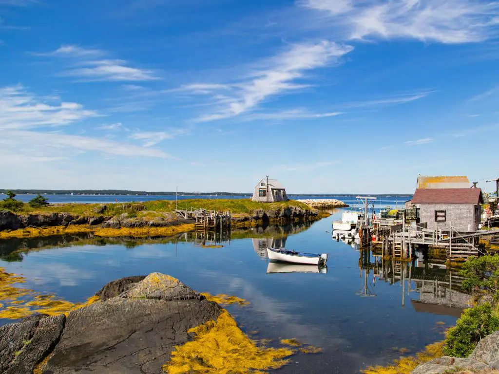 Nueva Escocia, Canadá, con un pequeño pueblo de pescadores pintoresco y típico y un puerto en las Marítimas, con mucha agua y cielos azules.