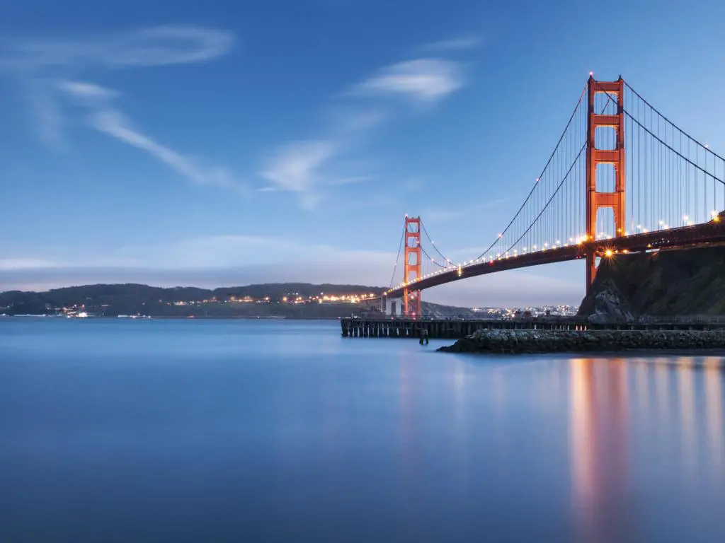 San Francisco, Estados Unidos, tomada en el puente Golden Gate al atardecer con luces en la distancia. 
