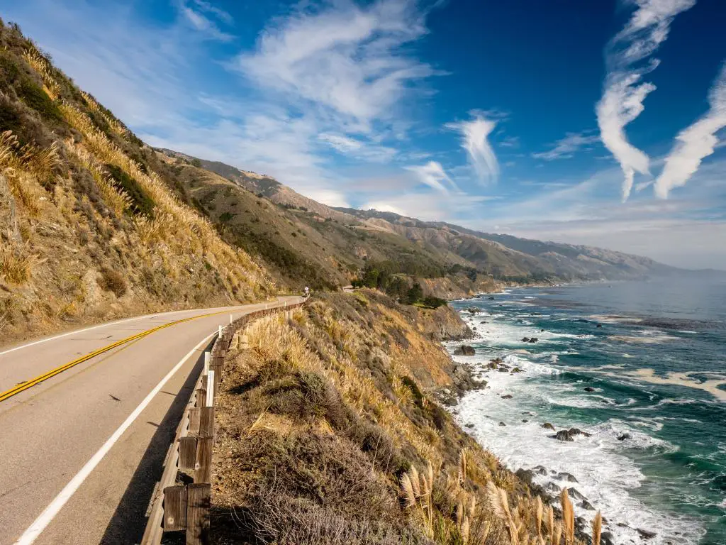 Un tramo de la autopista 1 en la costa del Pacífico, California, con olas rompiendo al costado de la carretera