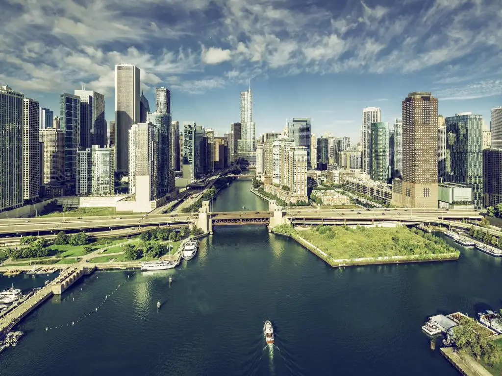 Río Chicago que corre entre edificios de gran altura con puentes que se cruzan y se abren a un puerto deportivo en primer plano