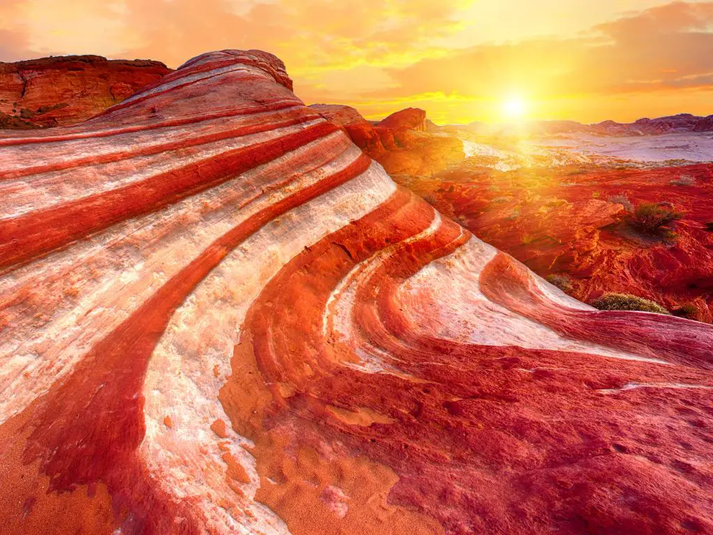 La puesta de sol de color rojo anaranjado que ilumina la Fire Wave Rock en el Parque Estatal Valley of Fire, Nevada