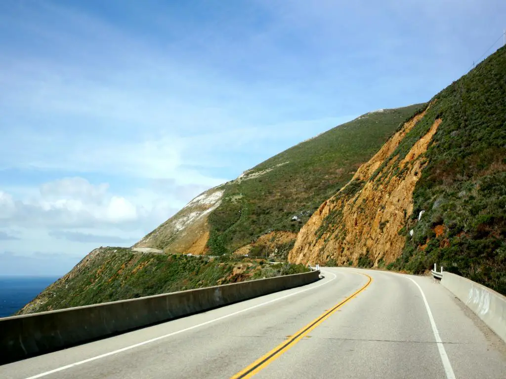 Una imagen de la carretera costera 101, California, en un cielo azul nublado.