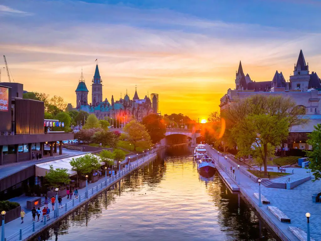 La ciudad de Ottawa, Canadá, con edificios a ambos lados del canal, el puente Mackenzie King en el fondo durante la puesta de sol.