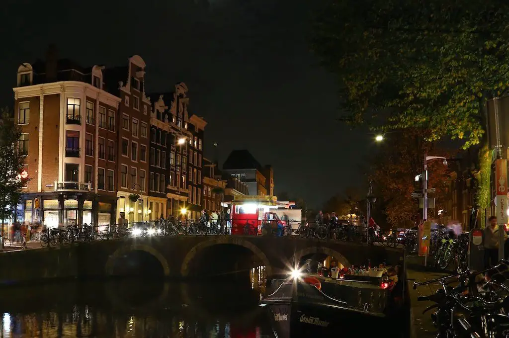 Bicicletas bordeando los canales de Ámsterdam de noche