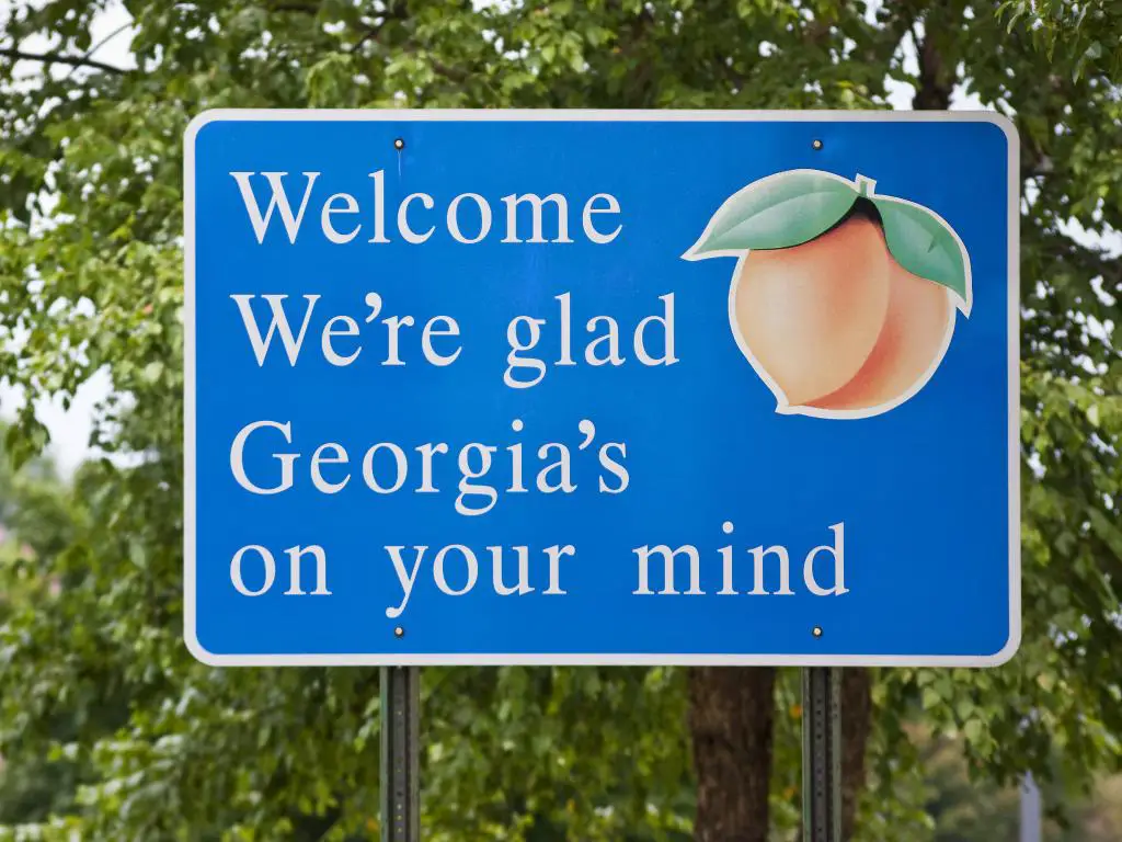 Un cartel azul de bienvenida al entrar en el estado de Georgia.  Lee: 