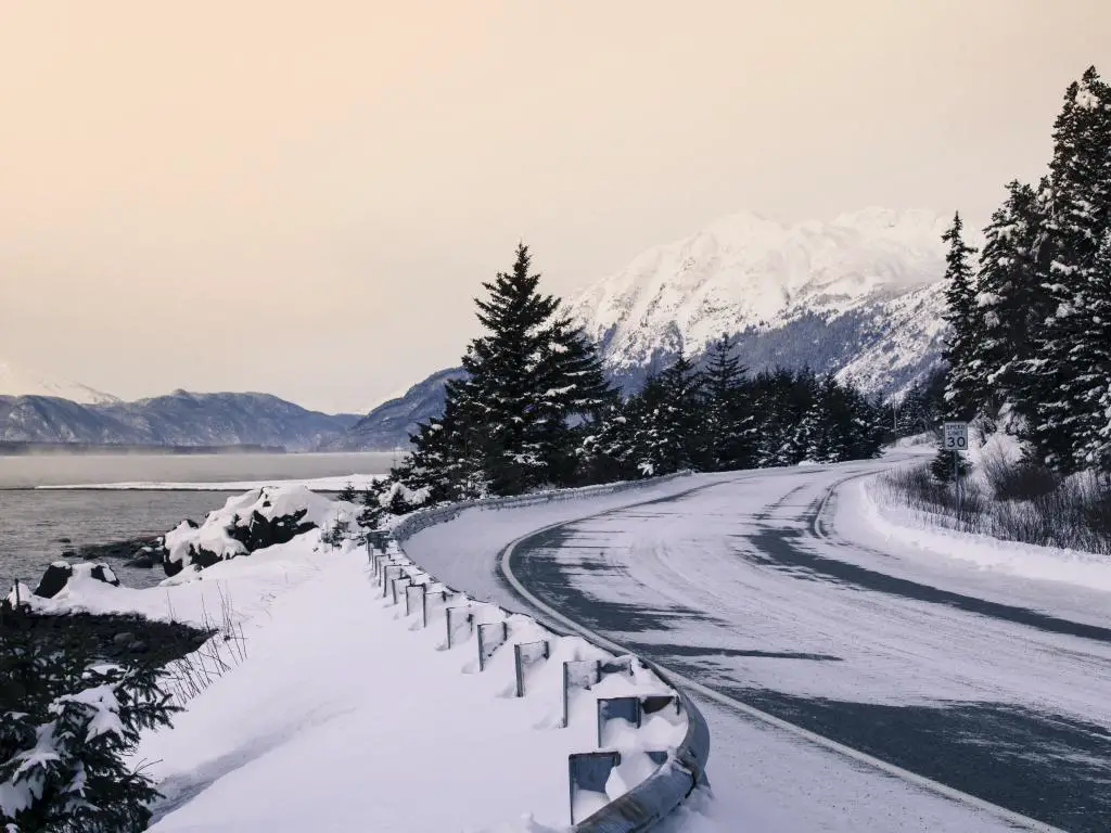 Una carretera con una capa de nieve en invierno cerca de Haines, Alaska