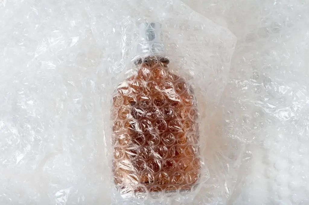 Botella de vidrio en plástico de burbujas